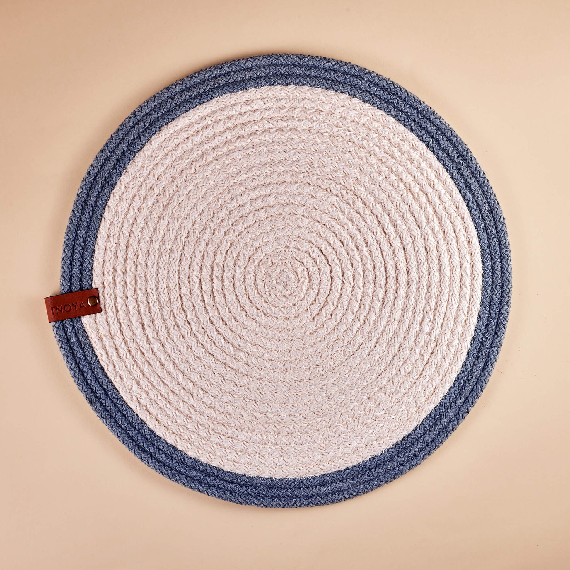 A round placemat with a white center and blue outer rim.