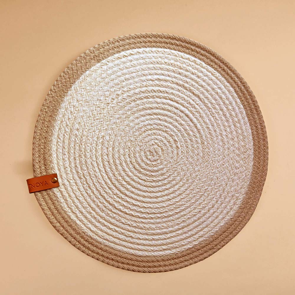 Round woven placemat with a leather tag on a beige background