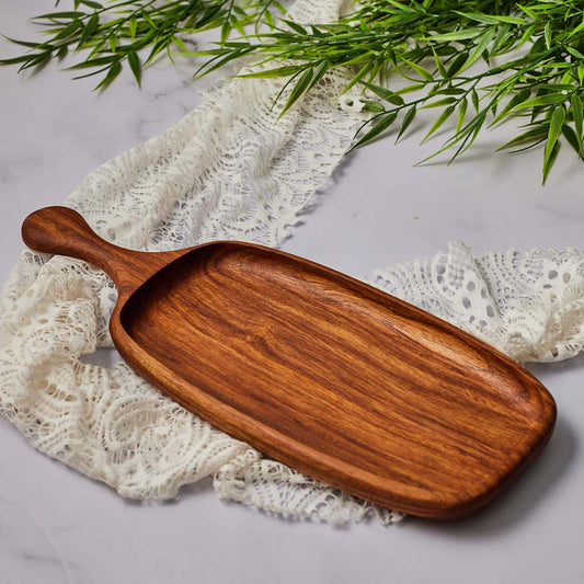 Handmade cheese serving tray made of rich, polished wood, placed on lace fabric.