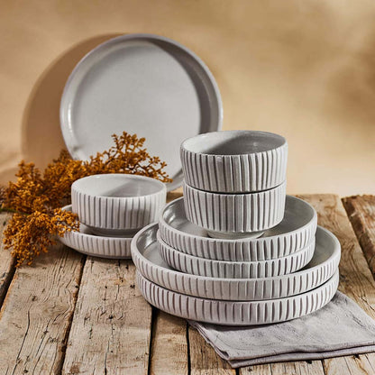 Set of gray ceramic dishes on a wooden table with a warm background