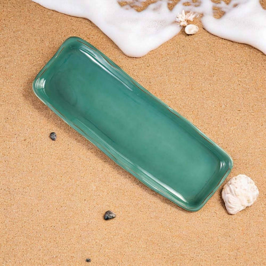 Jade ceramic Serving Platter on a sandy beach with shells and ocean foam.