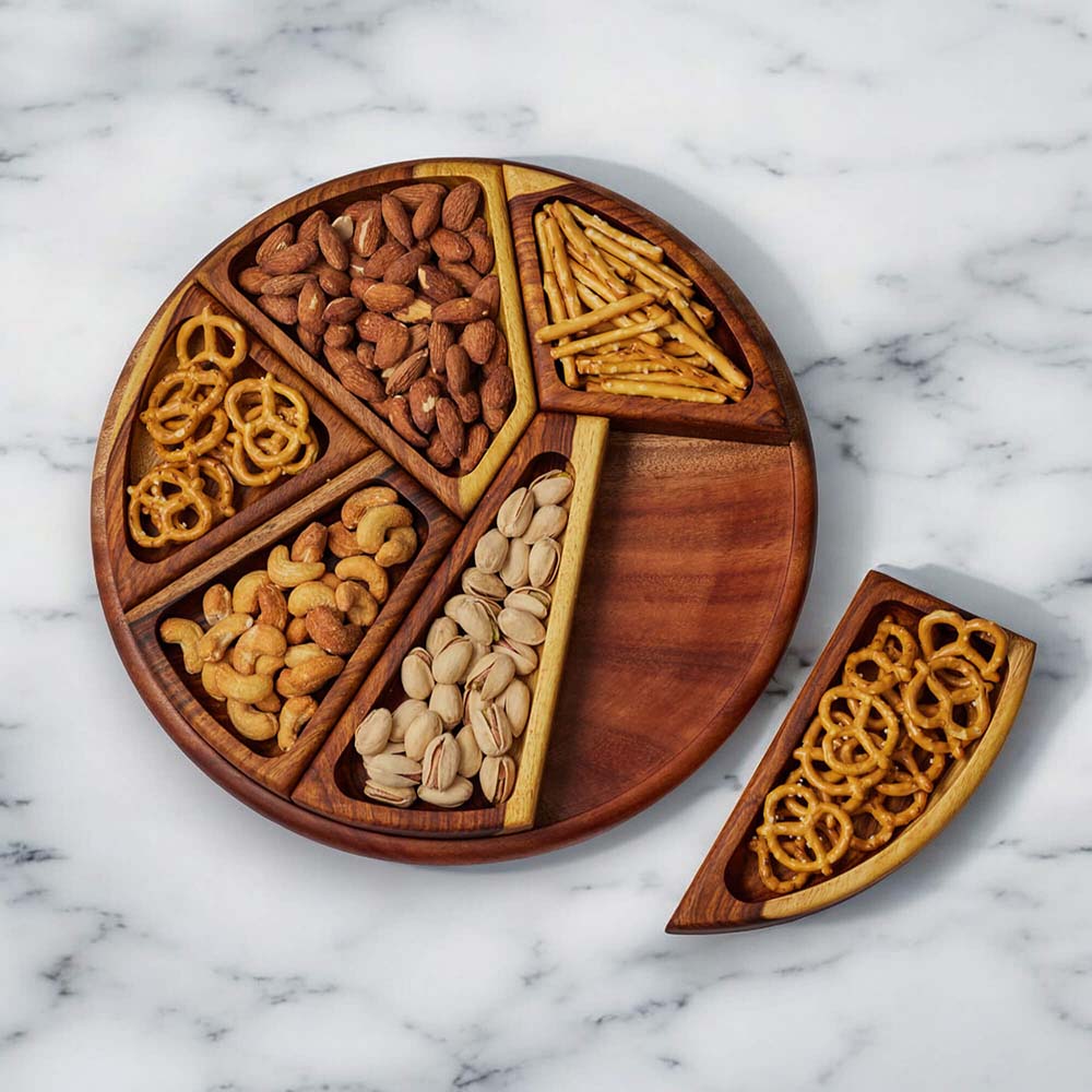 Wooden snack platter filled with nuts and pretzels on a marble countertop.
