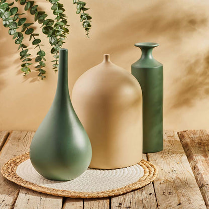 Minimal handmade vase set in olive and beige tones, arranged on a woven mat atop rustic wooden planks.