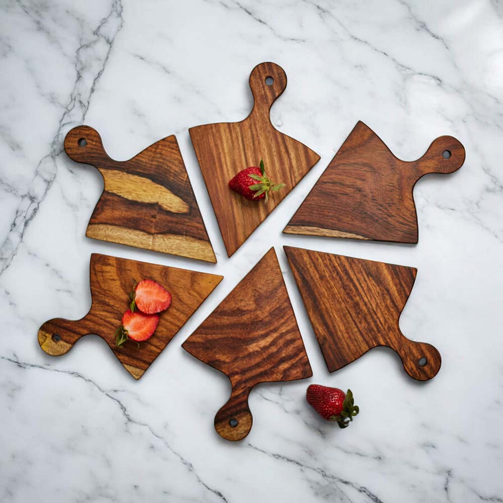 Set of wooden cutting boards with strawberries on a marble countertop.
