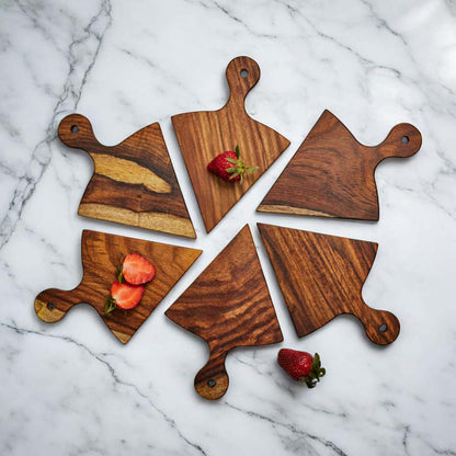 Set of wooden cutting boards with strawberries on a marble countertop.