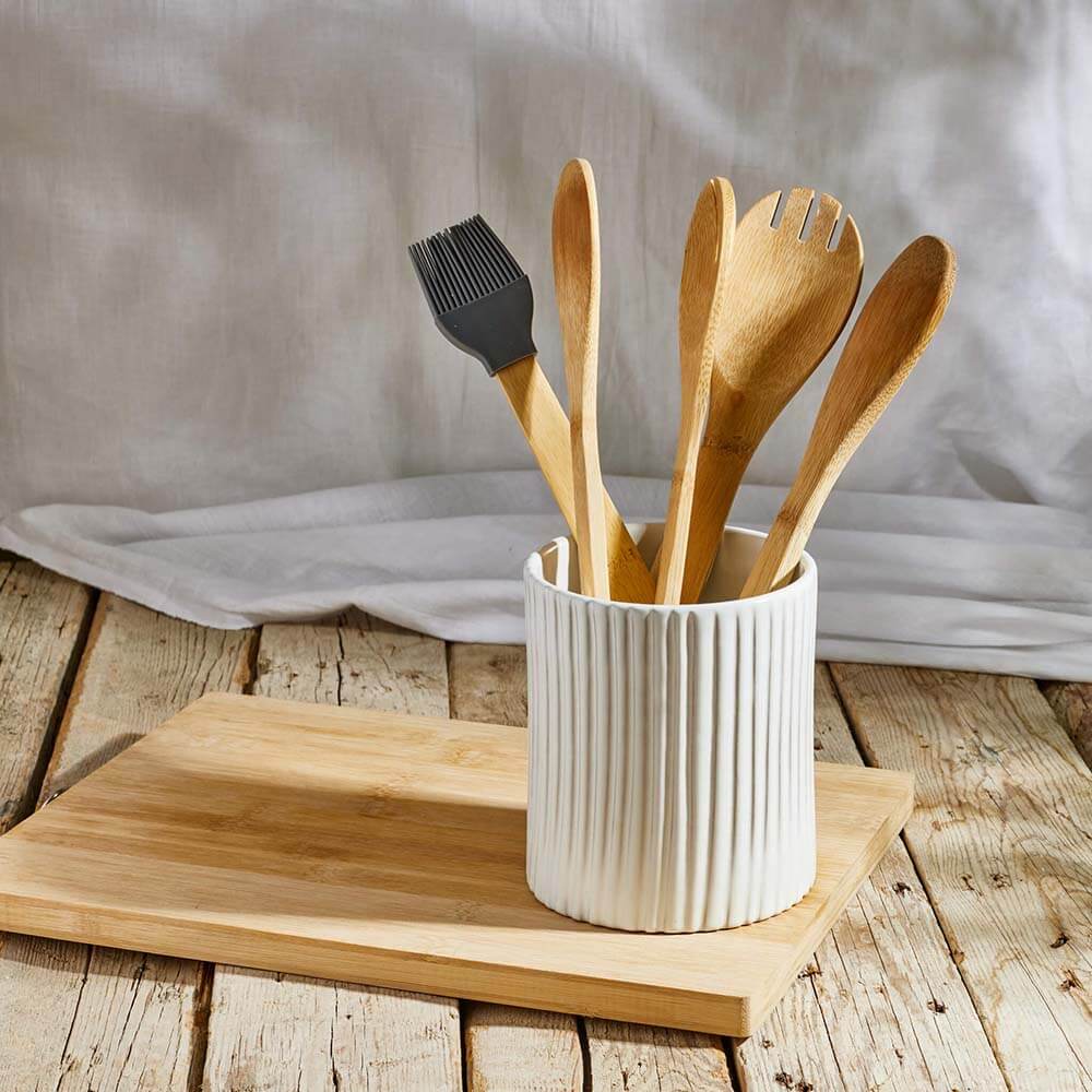 white ceramic utensils container on a wooden surface