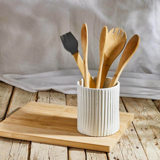 white ceramic utensils container on a wooden surface