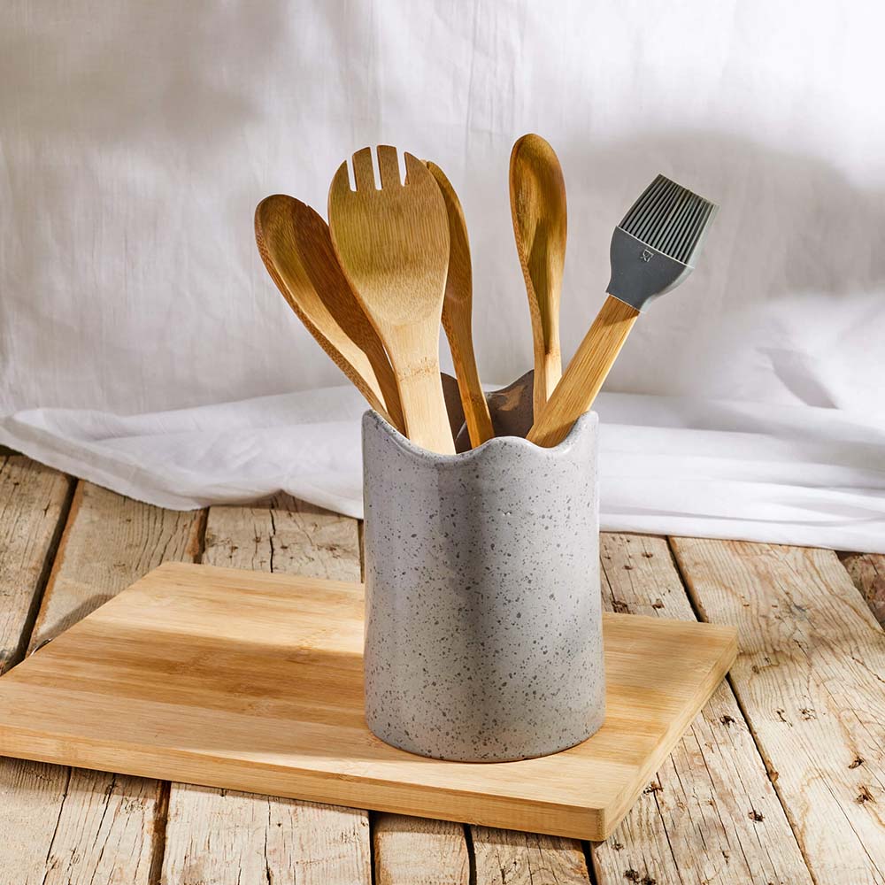 gray ceramic utensil holder on a wooden surface.